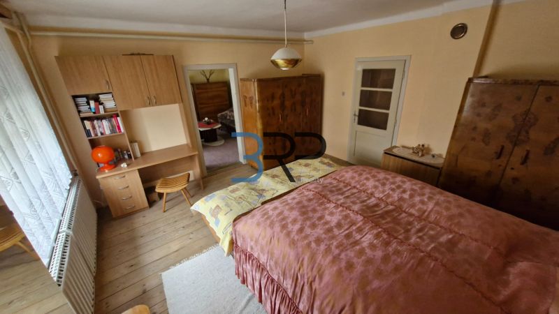 Mokrý Háj - predaj dom - Spálňa v rodinnom dome s dreveným dekorom a starožitným nábytkom.