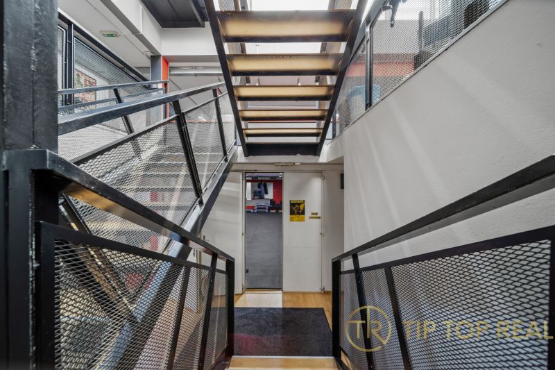 Na predaj PRIESTRANNÉ FITNESS CENTRUM na LUKRATÍVNEJ ADRESE RUŽINOVA - Chodba s kovovým schodiskom a mrežovým zábradlím v obchodných priestoroch.