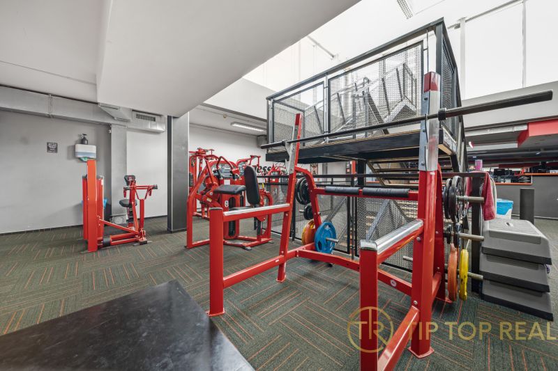 Na predaj PRIESTRANNÉ FITNESS CENTRUM na LUKRATÍVNEJ ADRESE RUŽINOVA - Posilňovacie stroje a lavičky, jasné osvetlenie, obchodné priestory so športovým vybavením.