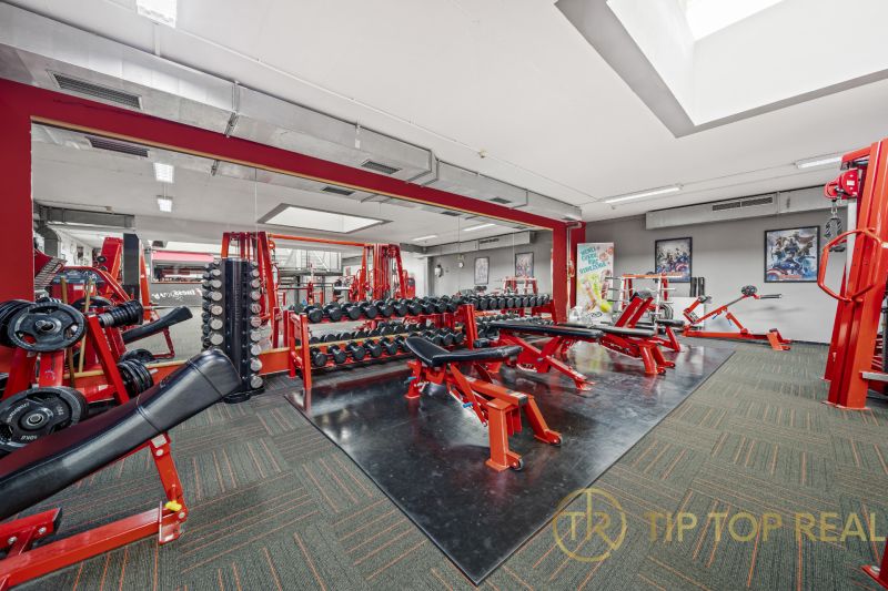 Na predaj PRIESTRANNÉ FITNESS CENTRUM na LUKRATÍVNEJ ADRESE RUŽINOVA - Fitness centrum s posilňovacími zariadeniami, lavicami a zrkadlami v obchodných priestoroch.