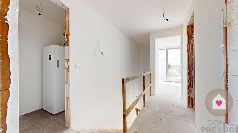 KRÁĽOVÁ PRI SENCI – SKOLAUDOVANÁ novostavba 4i RD v štandarde - Interiér rodinného domu s bielymi stenami a nezakrytou konštrukciou schodiska.
