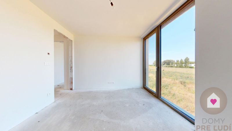 KRÁĽOVÁ PRI SENCI – SKOLAUDOVANÁ novostavba 4i RD v štandarde - Prázdna miestnosť v rodinnom dome s veľkými oknami a výhľadom na exteriér.