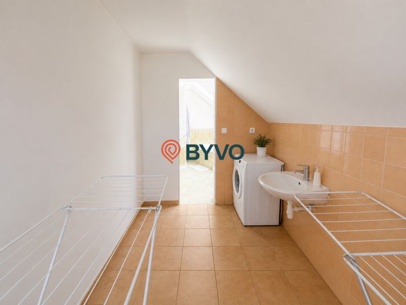 6-izbový rodinný dom v Šamoríne | 201 m² | pozemok 451 m² | - Práčovňa v rodinnom dome s práčkou, umývadlom a sušiakom na bielizeň.