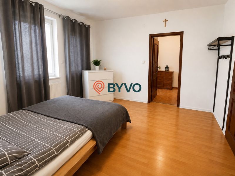 6-izbový rodinný dom v Šamoríne | 201 m² | pozemok 451 m² | - Spálňa v rodinnom dome s posteľou, komodou a podlahou s dreveným dekorom.