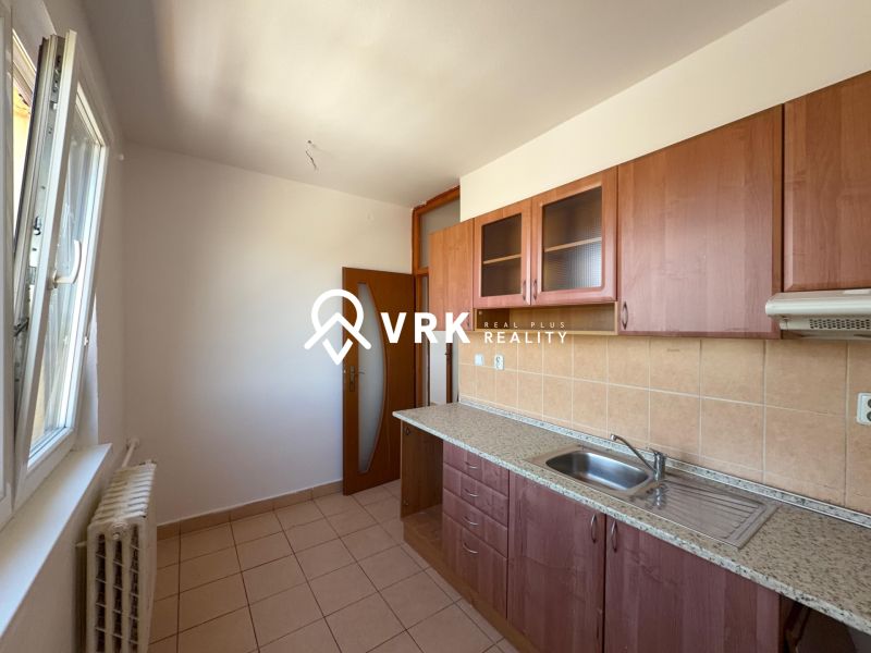 NA PREDAJ 2-IZBOVÉ BYTY, STROMOVÁ, KOŠICE- STARÉ MESTO - Kuchyňa v 2-izbovom byte s keramickou dlažbou a drevenými skrinkami.
