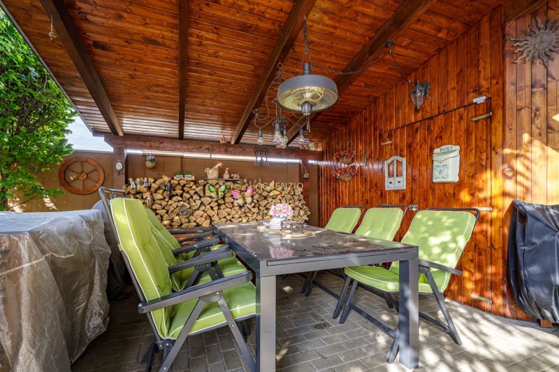 4 izbový rodinný dom Nová Dedinka, predaj, 543m2  - Drevený altánok s kamennou podlahou a zelenými stoličkami pri rodinnom dome.