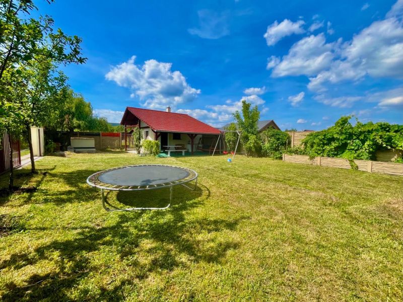 Záhrada s komfortne vybudovaným zázemím – Žabí majer - Záhrady v Bratislave – Rači na Žabom majeri s trampolínou a altánkom pod modrou oblohou.