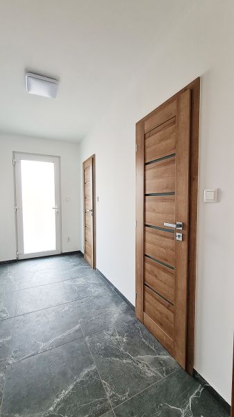 / Novostavba, moderný bungalov, dokončený na kľúč  - Interiér Rodinného domu s kamennou podlahou a drevenými dverami.