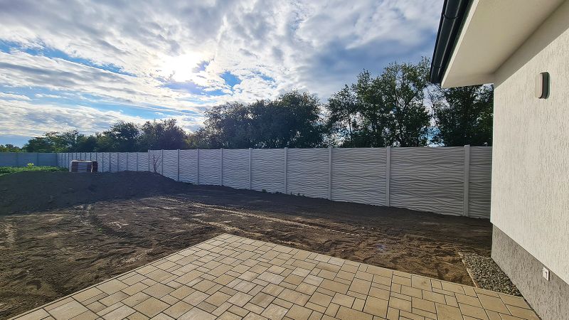 / Novostavba, moderný bungalov, dokončený na kľúč  - Pavlač rodinného domu v Senci pri plote, čiastočne zatienená slnkom.