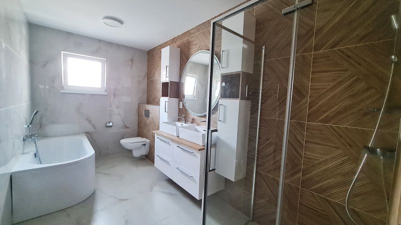 / Novostavba, moderný bungalov, dokončený na kľúč  - Kúpeľňa s vaňou, sprchou a dvojitým umývadlom v rodinnom dome.