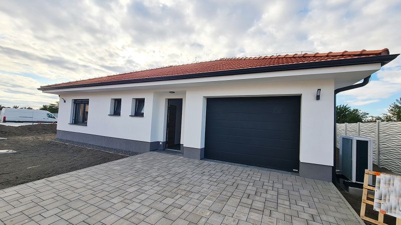 / Novostavba, moderný bungalov, dokončený na kľúč  - Rodinný dom v Senci s červenou strechou a dláždenou príjazdovou cestou.