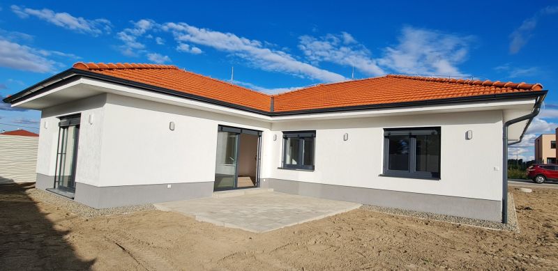 / Novostavba, moderný bungalov, dokončený na kľúč  - Rodinný dom v Novom Svete so šikmou červenou strechou a terasou.