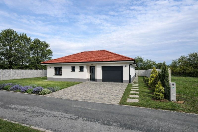 / Novostavba, moderný bungalov, dokončený na kľúč  - Rodinný dom v Senci s červenou strechou, garážou a udržiavanou záhradou.