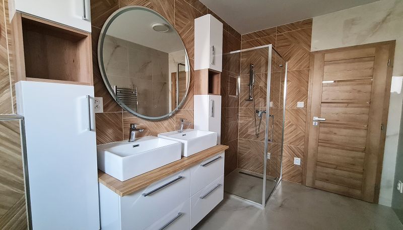 / Novostavba, moderný bungalov, dokončený na kľúč  - Kúpeľňa s dvoma umývadlami, sprchovým kútom a dreveným dekorom.