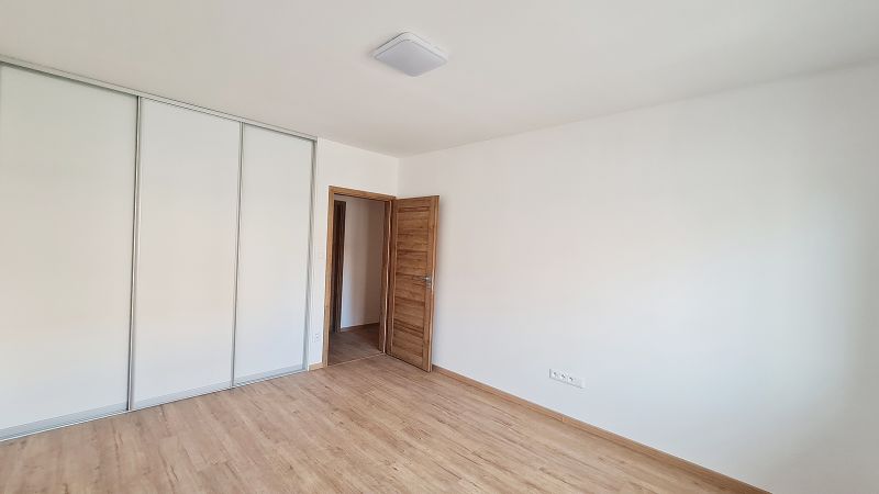/ Novostavba, moderný bungalov, dokončený na kľúč  - Izba v rodinnom dome s podlahou s dreveným dekorom a vstavanou skriňou.