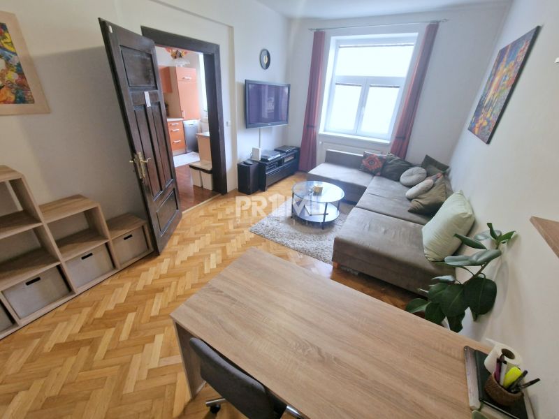 Veľký 3i byt, vysoké stropy,  pivnica, garáž, Murgašova, Staré Mesto - Obývačka v 3-izbovom byte disponuje pohodlnou sedacou súpravou a podlahou s dreveným dekorom.