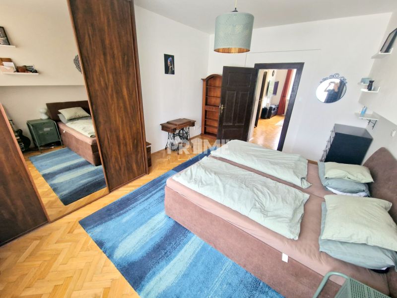 Veľký 3i byt, vysoké stropy,  pivnica, garáž, Murgašova, Staré Mesto - Spálňa v 3-izbovom byte s posteľou, zrkadlovou skriňou a modrým kobercom.