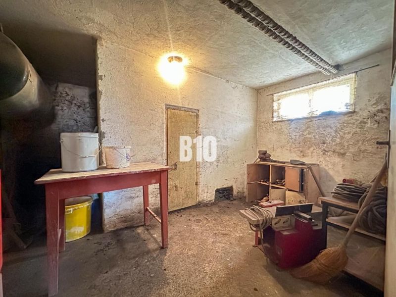 Rodinný dom s veľkým pozemkom a nádhernými výhľadmi – Dolný Milochov - Pivnica rodinného domu s nábytkom a vedrami na stole.
