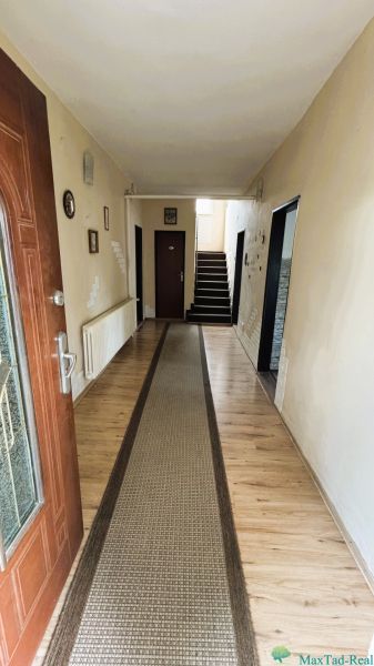 Dve generácie pod jednou strechou, Novosad, rodinný dom, 99.000€ - Vstupná chodba v rodinnom dome s podlahou s dreveným dekorom a kobercovým chodníkom.