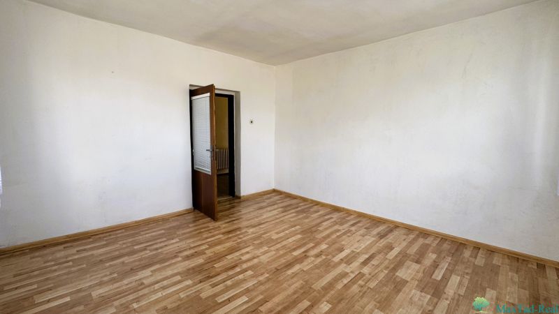 Dve generácie pod jednou strechou, Novosad, rodinný dom, 99.000€ - Izba v Rodinnom dome s podlahou s dreveným dekorom a otvorenými dverami.