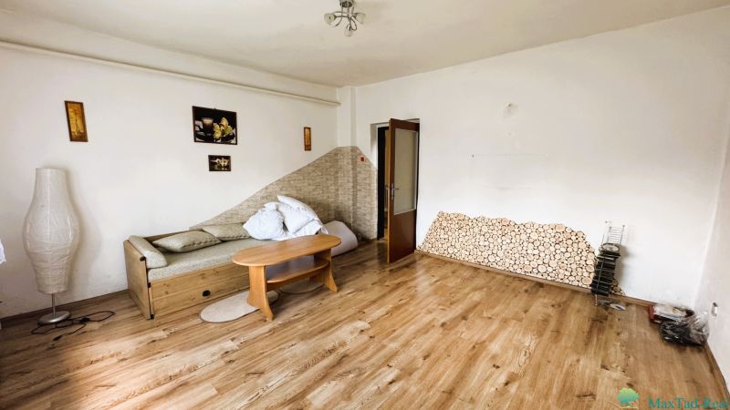 Dve generácie pod jednou strechou, Novosad, rodinný dom, 99.000€ - Obývacia izba v rodinnom dome s pohovkou a podlahou s dreveným dekorom.