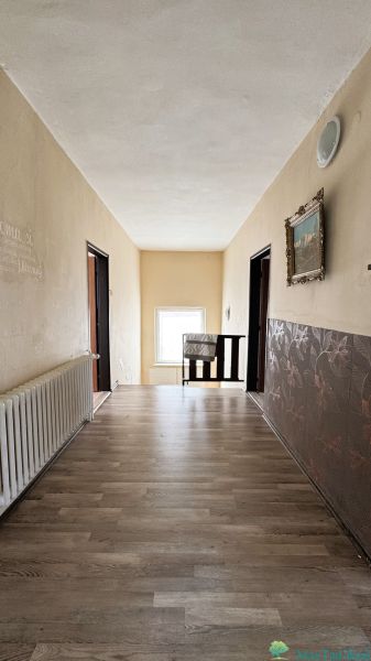 Dve generácie pod jednou strechou, Novosad, rodinný dom, 99.000€ - Chodba v rodinnom dome s podlahou s dreveným dekorom, ozdobnými stenami a radiátorom.
