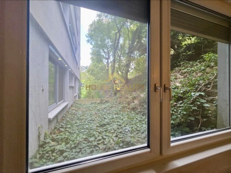 Novostavba 1 izbový byt, Sklenárska cesta, Bratislava I. Staré Mesto - Výhľad z okna 1-izbového bytu na zelený porast a vedľajšiu budovu.