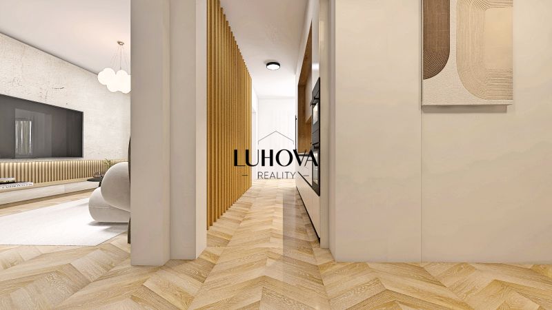Priestranný 2-izbový byt - Chodba s podlahou s dreveným dekorom vedie do obývačky v 2-izbovom byte.