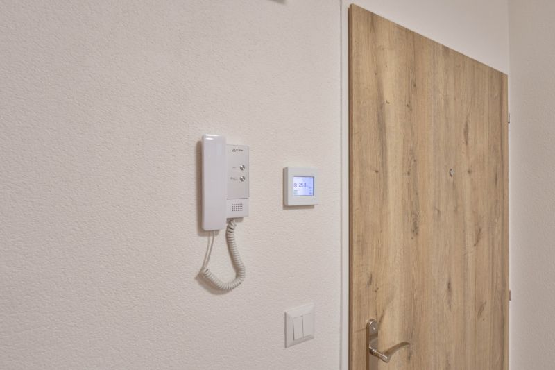 NOVÁ GARSÓNKA V CENTRE - MINÚTU OD NÁMESTIA - Dvere s dreveným dekorom a interkom v garsónke.