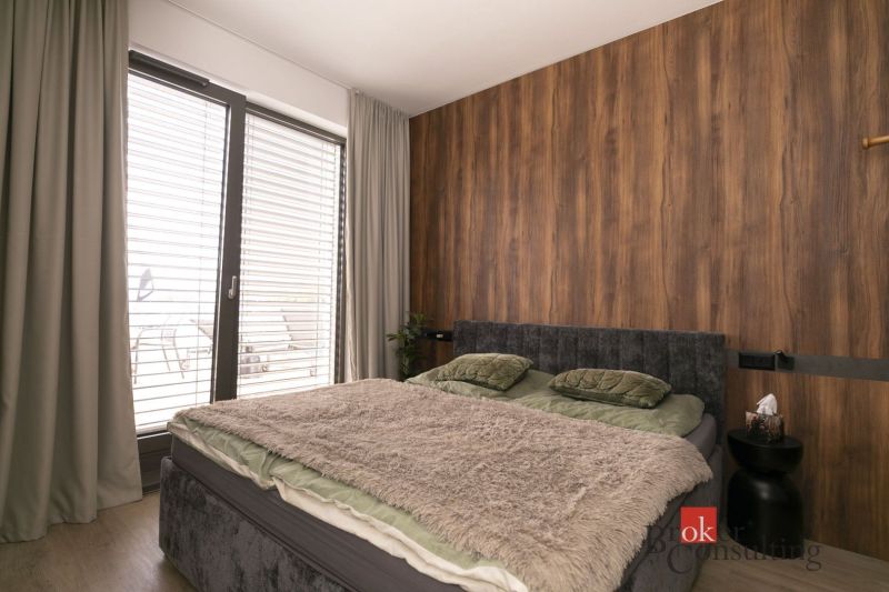 Na predaj luxusný 2-izbový byt, výnimočná terasa pre náročných - Dvojlôžková posteľ s mäkkou prikrývkou v 2-izbovom byte s podlahou z dreveným dekorom.