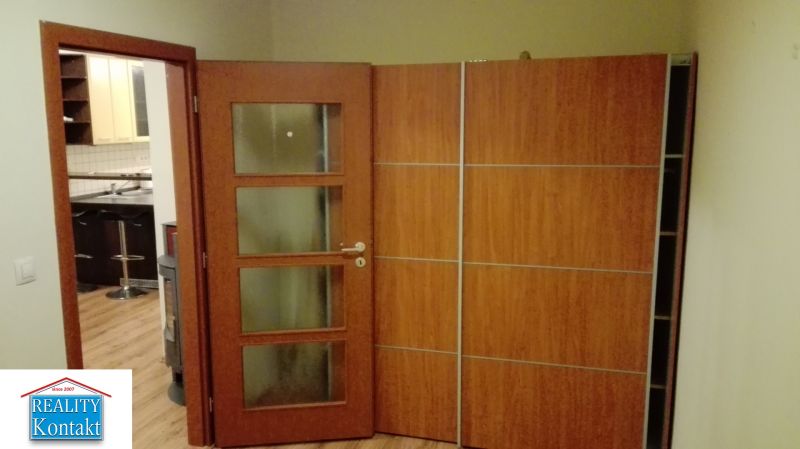 Na prenájom 3-izbový byt so záhradkou v Nových Zámkoch - Otváracie dvere do kuchyne, podlaha s dreveným dekorom, vchod vedúci do 3-izbového bytu.