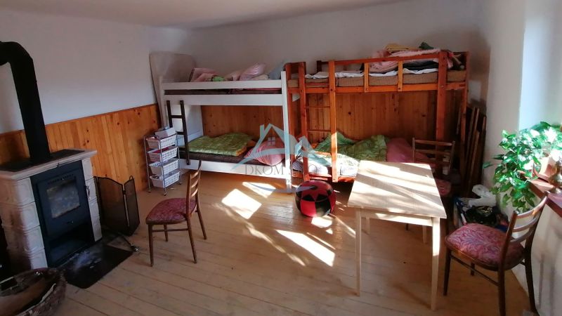 Dva vidiecke domy na pozemku 1,6ha D. Strehová (Prieloh), V. Krtíš. - Poschodové postele, krbové kachle a nábytok v miestnosti v rodinnom dome.