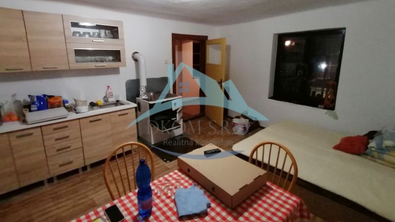 Dva vidiecke domy na pozemku 1,6ha D. Strehová (Prieloh), V. Krtíš. - Kuchyňa so sporákom, jedálenským stolom a posteľou, vhodná pre rodinný dom.