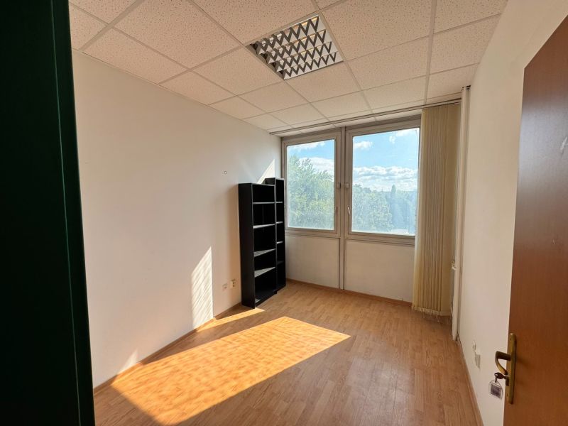 100 Euro vrátane energii - Kancelária 9,7 m2 na Tomášikovej ul.  - Kancelárie s podlahou s dreveným dekorom a oknami s výhľadom na zeleň.