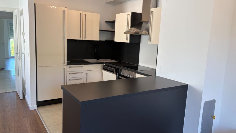 3-izbový zariadený byt s veľkou terasou pri lese, Wolfsthal - Kuchyňa v 3-izbovom byte s elegantnou čiernou doskou a svetlými skrinkami.