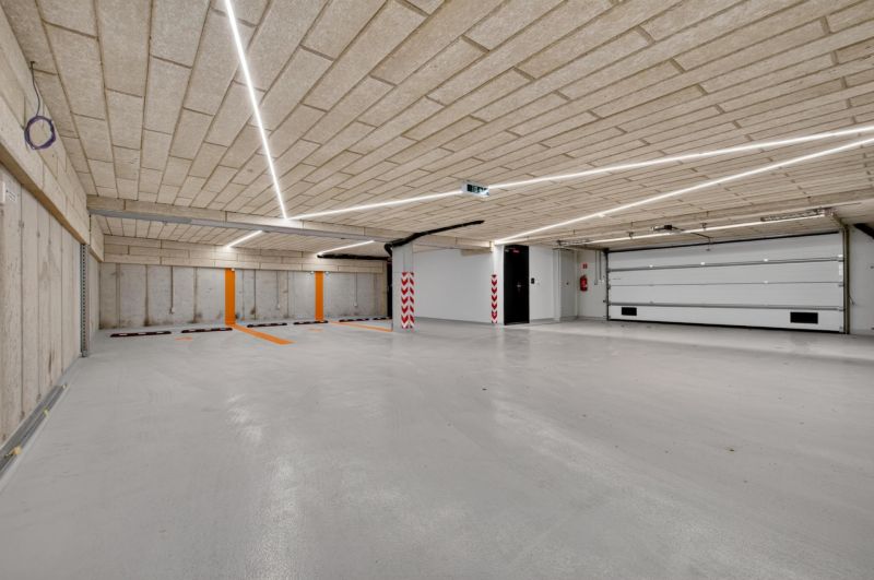 I PREDAJ Výnimočný 5izb. byt s veľkorysou terasou,Staré Mesto - Parkovacia garáž s betónovým stropom a podlahou, osvetlená lineárnymi svietidlami.