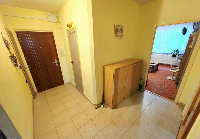 4 izbový byt Bánovce nad Bebravou /CENTRUM - STRED / 80 m2/ PIVNICA - Predsieň v 4-izbovom byte so vstupnými dverami a nábytkom na odkladanie.