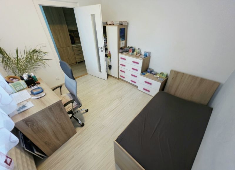 4 izbový byt Bánovce nad Bebravou /CENTRUM - STRED / 80 m2/ PIVNICA - Izba v 4-izbovom byte s dreveným dekorom podlahy, posteľou a písacím stolom.