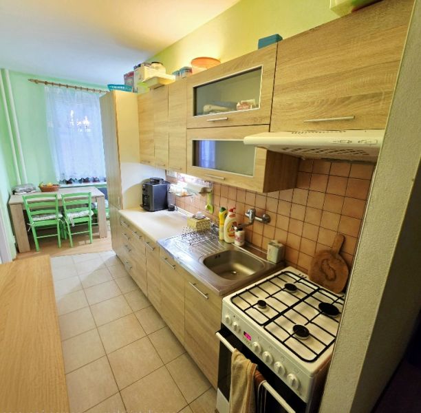 4 izbový byt Bánovce nad Bebravou /CENTRUM - STRED / 80 m2/ PIVNICA - Kuchyňa v 4-izbovom byte s dreveným dekorom a jedálenským kútom.