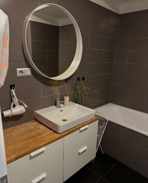 2-izb. byt Pri Hrubej lúke v projekte Tammi, pivnica, garážové státie - Kúpeľňa v 2-izbovom byte s umývadlom, zrkadlom a vaňou, elegantné hnedé obklady.