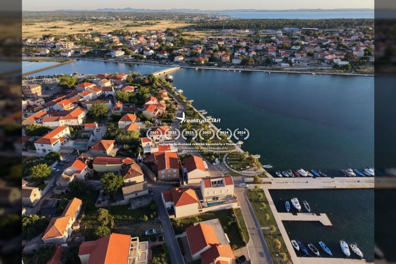 Nin – luxusné apartmány v novom projekte s bazénom - Letecký pohľad na pobrežnú oblasť mesta Nin so strechami víl a prístavom.