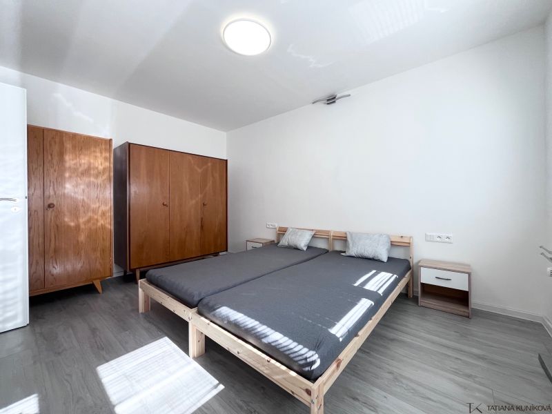 NA PRENÁJOM! Slnečný a zariadený 3i byt 68 m2, ul. Švermova, Trenčín - Spálňa s posteľou, drevenými skriňami a podlahou s dreveným dekorom v 3-izbovom byte.