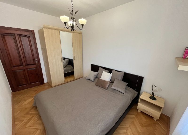 Priestranný a kvalitne zariadený 3-izbový byt – Bratislava, Petržalka - Spálňa s posteľou, skriňou a podlahou s dreveným dekorom v 3-izbovom byte.