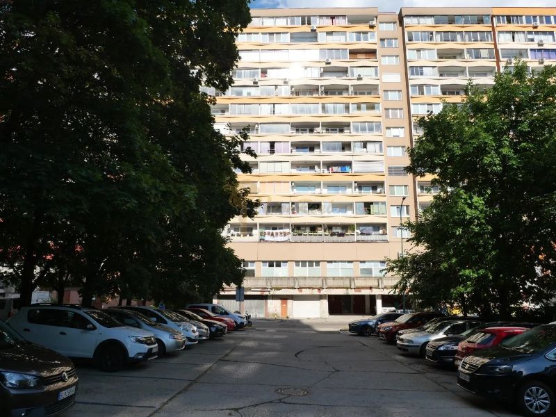 1-izb.byt, Holíčska, Petržalka, 1 p./12 - Bytový dom na Holíčskej v Bratislave - Petržalke obklopujú zaparkované autá a stromy.