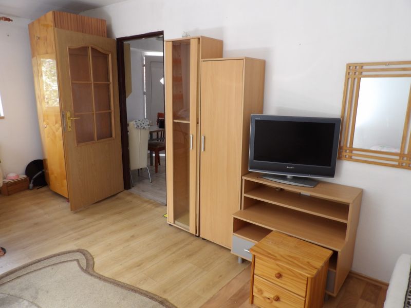 Nájomné bývanie v centre Serede - Obývacia izba v 2-izbovom byte s nábytkom a podlahou s dreveným dekorom.
