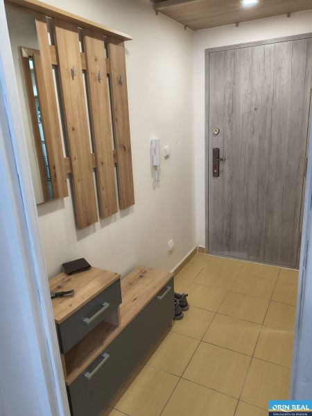 KOMPLET ZARIADENÁ GARSÓNKA PRI PLAVÁRNI - Vstupná hala garsónky s vešiakmi, botníkom a šedými dverami.