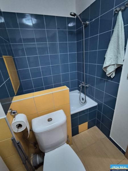 KOMPLET ZARIADENÁ GARSÓNKA PRI PLAVÁRNI - Kúpeľňa v garsónke s farebnými obkladmi a sprchovacím kútom.