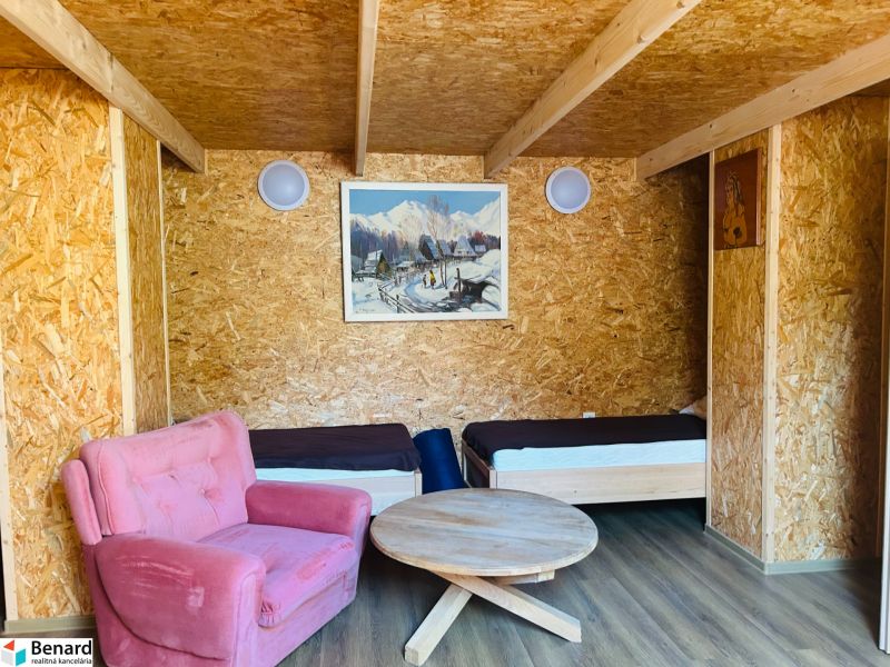 RD NA BÝVANIE AJ PODNIKANIE,1630m2,  SABINOVSKÁ Ul., PREŠOV - Izba v rodinnom dome s dvomi posteľami, ružovým kreslom a podlahou s dreveným dekorom.
