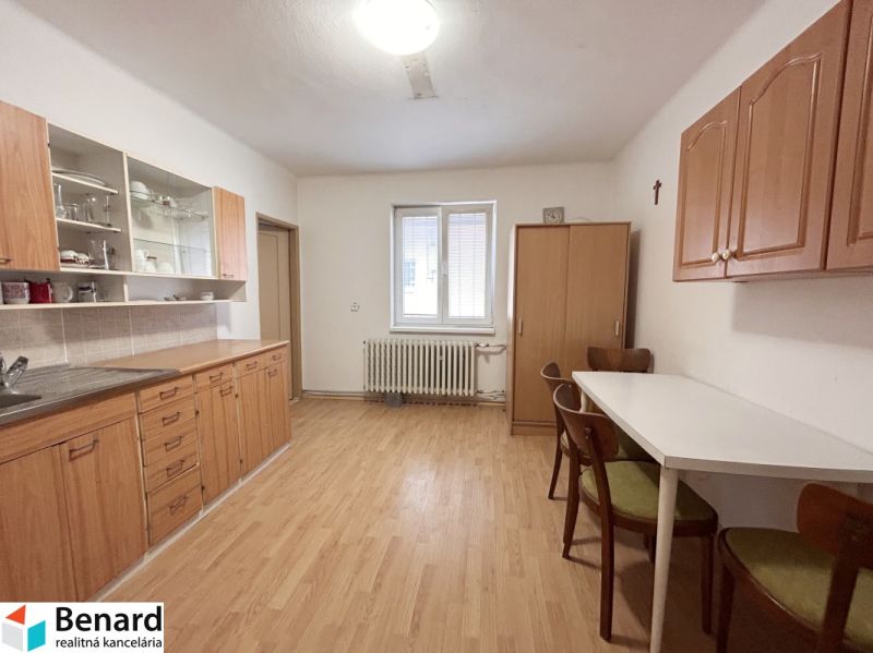 RD NA BÝVANIE AJ PODNIKANIE,1630m2,  SABINOVSKÁ Ul., PREŠOV - Kuchyňa v rodinnom dome s podlahou s dreveným dekorom, drevenými skrinkami a jedálenským stolom.