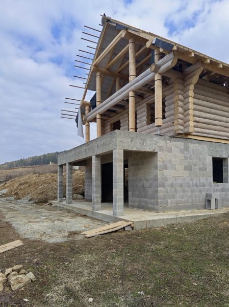 NA PREDAJ - Necpaly - zrubový dom (hrubá stavba) k dokončeniu - Stavba dreveného rodinného domu v Necpaloch, zobrazená s betónovým prízemím.